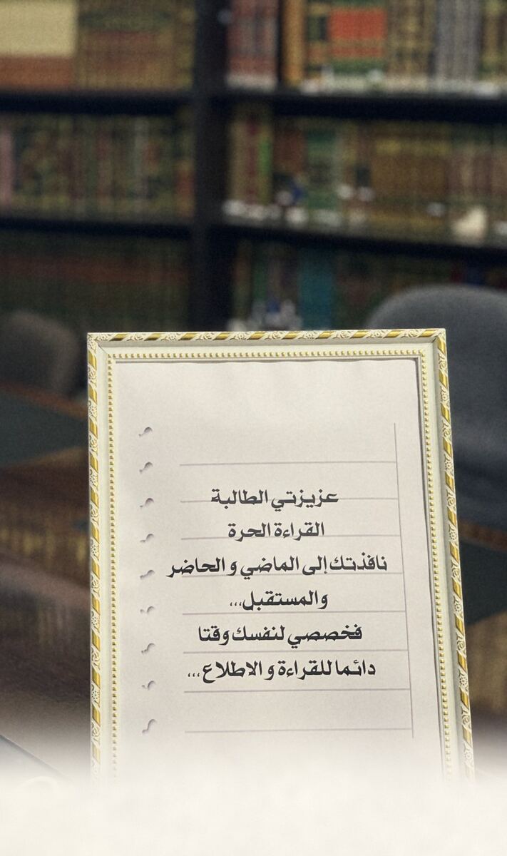 ملاحظة مؤطّرة على مكتب مكتبة مركز تعلّم أمام رفوف الكتب