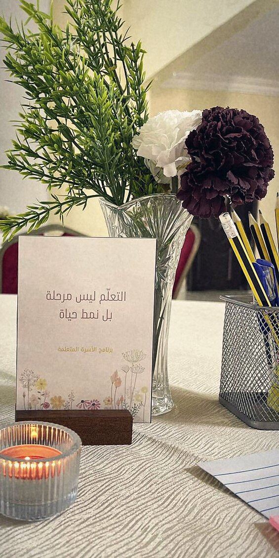 بطاقة على طاولة: التعلّم ليس مرحلة بل نمط حياة — برنامج الأسرة المتعلمة