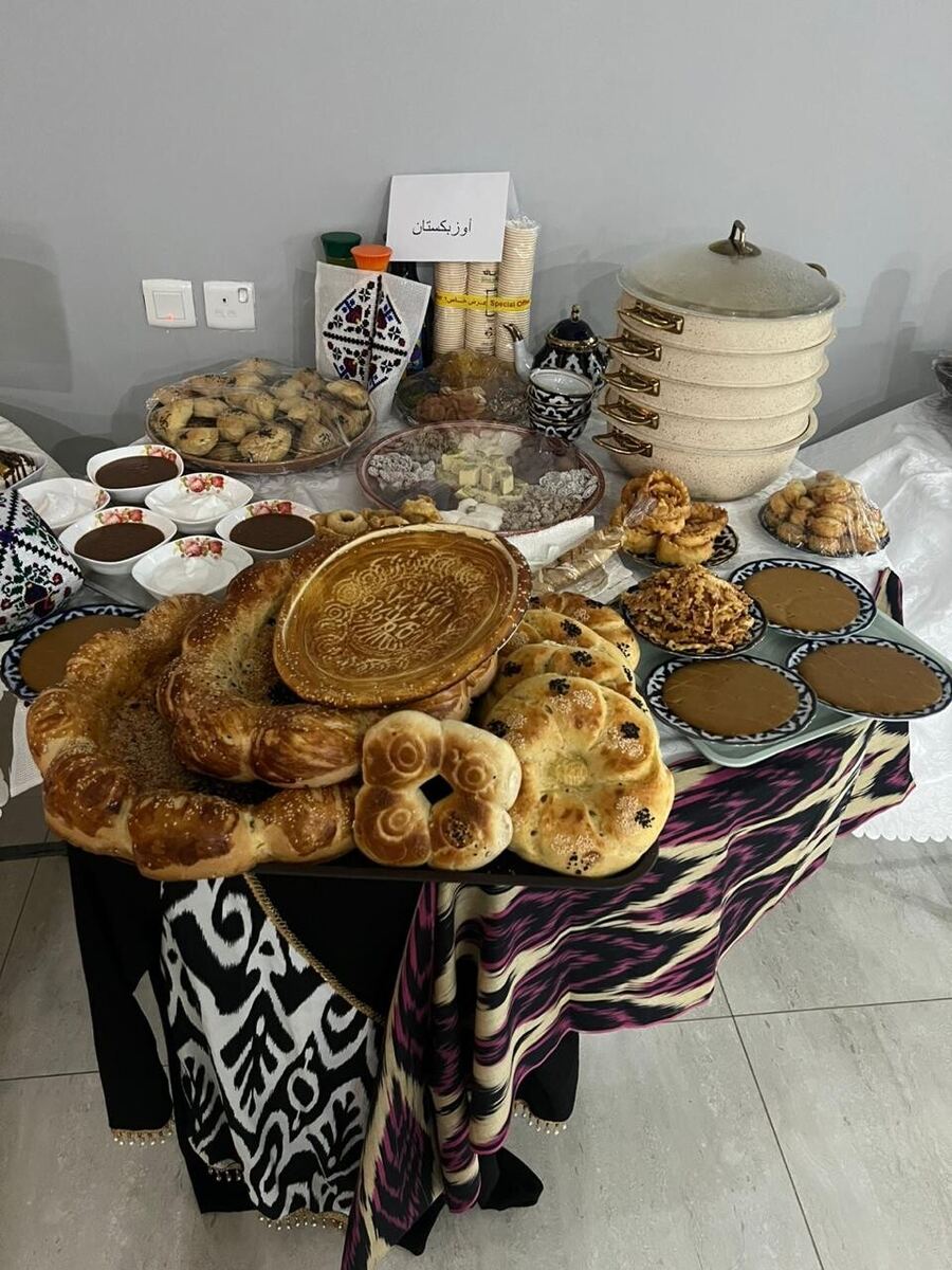 مائدة عليها خبز نان مزخرف وسمبوسة وأقمشة إيكات